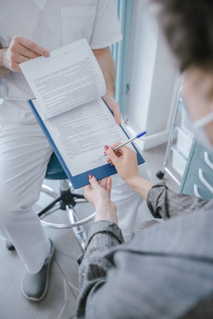 A patient signs a consent form in a medical facility, ensuring informed healthcare decisions.